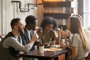 Student sat round table eating takeaway pizza